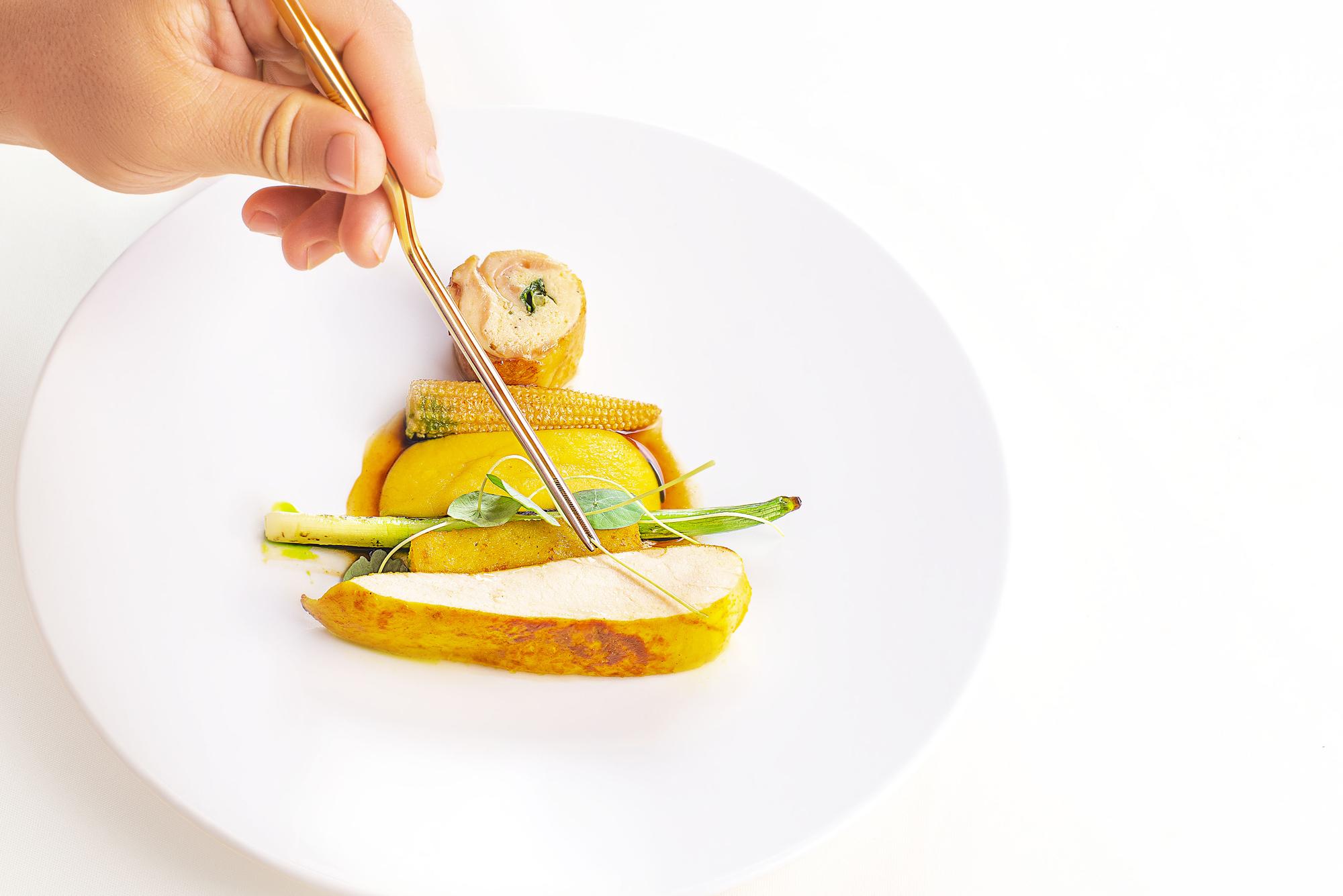 Close-up of plated dish and hands